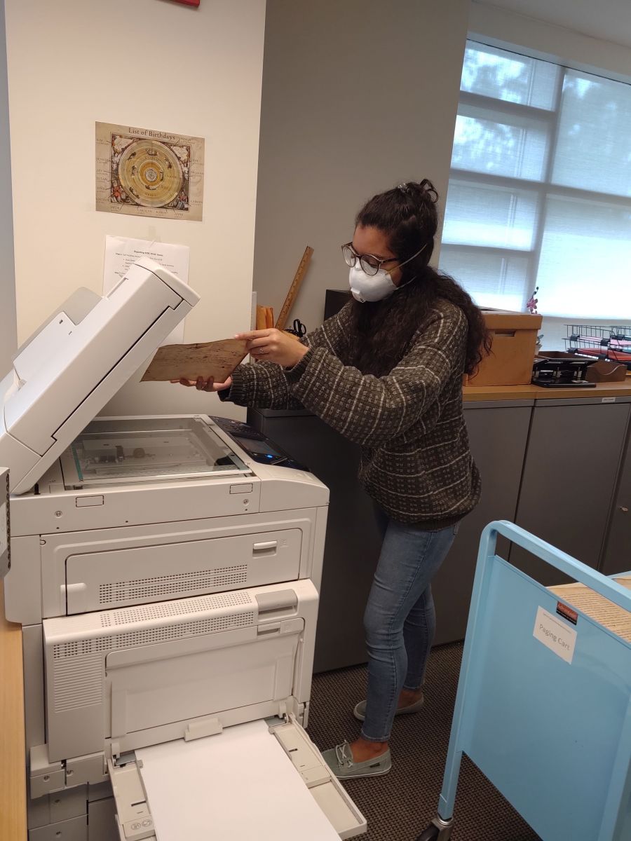 Student worker, Gabriela Montesdeoca, working with moldy papers at a huge Xerox machine