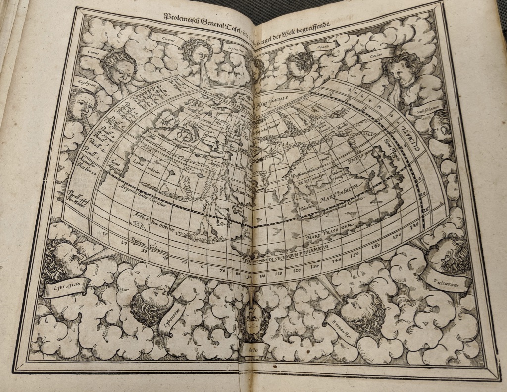 Ptolemaic map of the northern hemisphere with cherub heads blowing wind at the map