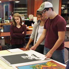 Students examine film posters in Special Collections