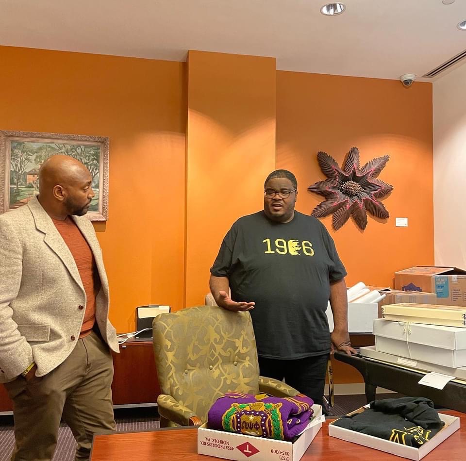 Andre Taylor (right) talks with historian Frederick Murphy about the artifacts used in, Strollin’: A History of Black Greek Letter Organizations at William & Mary.