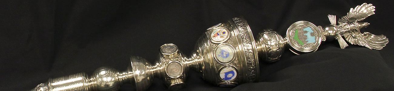 The W&M ceremonial mace in silver with emblems of the W&M coat of arms, American eagle, and Virginia flag.