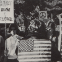 Students and community members holding signs, including one reading "Peace Now & Forever" during a demonstration in the Wren Courtyard, circa fall 1969