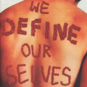 Red beads strung into letters to form the text "We Define Our Selves" on a person's bare back
