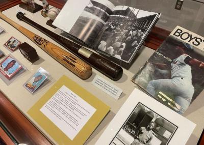 Exhibit case with baseball bats, trading cards and various photos and magazines