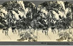Stereoview showing Santa in his sleigh, which is pulled by four reindeer. Snowy landscape in the background.