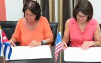 Caridad Rojas Zayas and Ann Marie Stock signing agreement